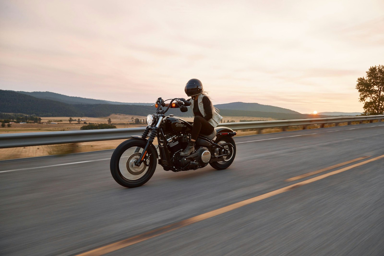 Motorcyclist riding on an open road at dusk
